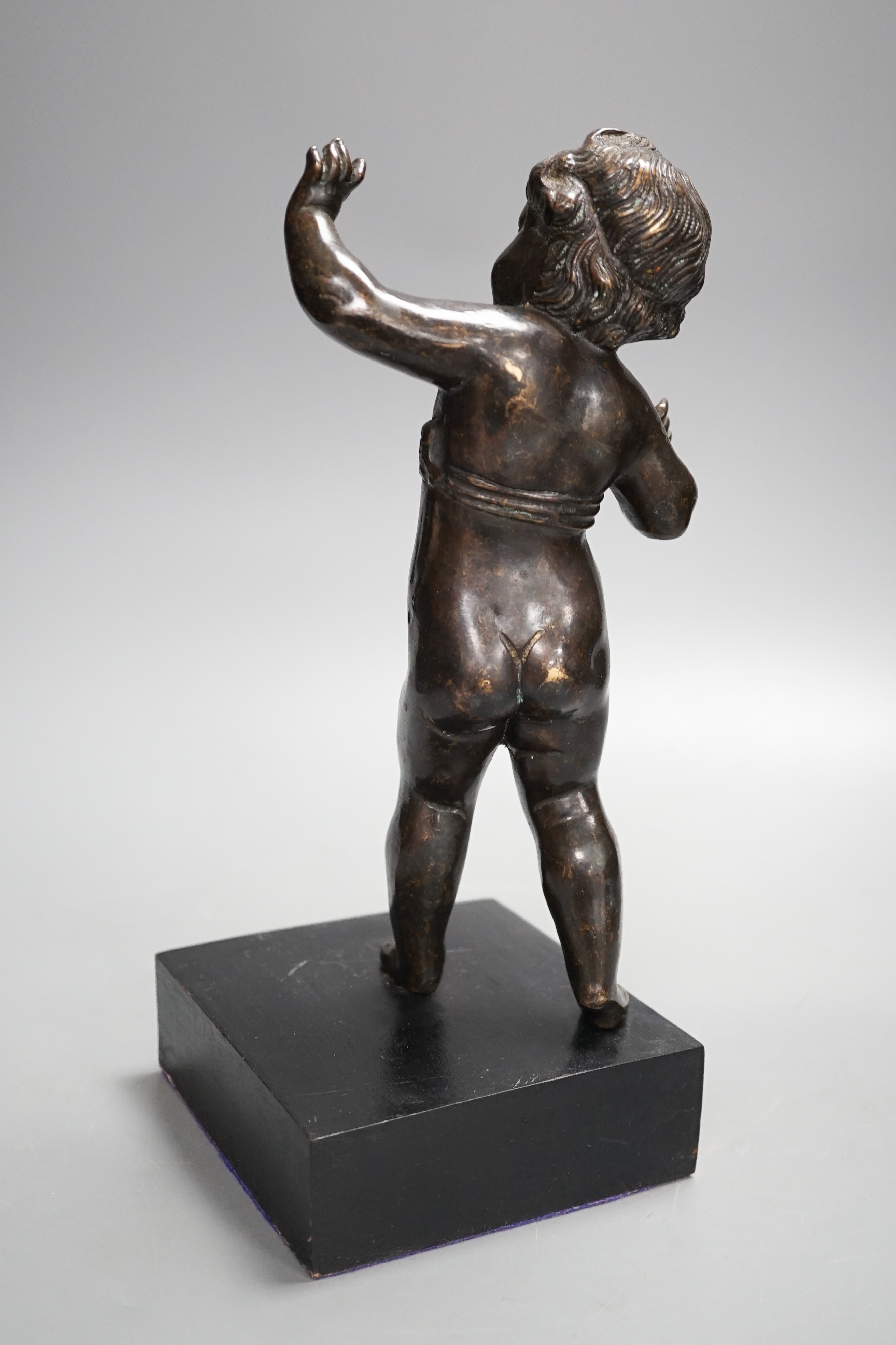 A 20th century bronze putto on wooden stand 29cm including stand